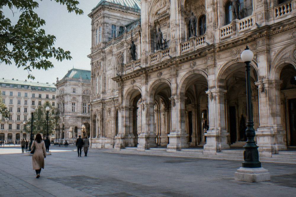 The Staatsoper arched loggia and carved stone details seen from the pavement in clear daylight
