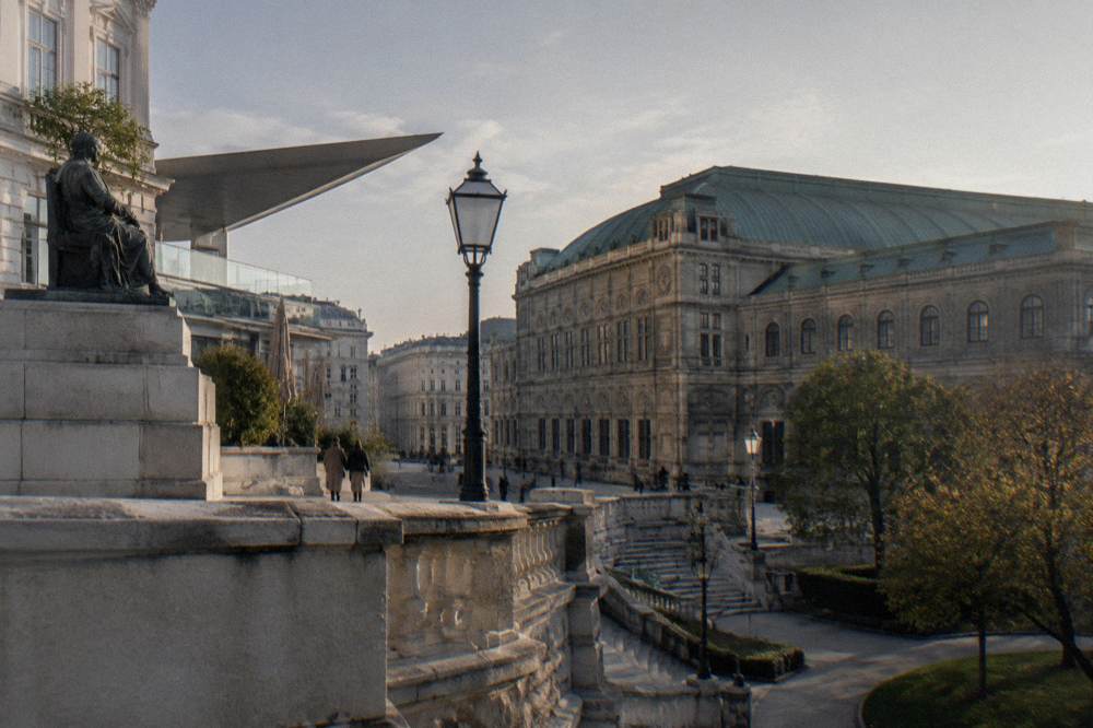 The Albertina terrace wall and Albertinaplatz next to the State Opera in soft morning light with the opera roofline beyond