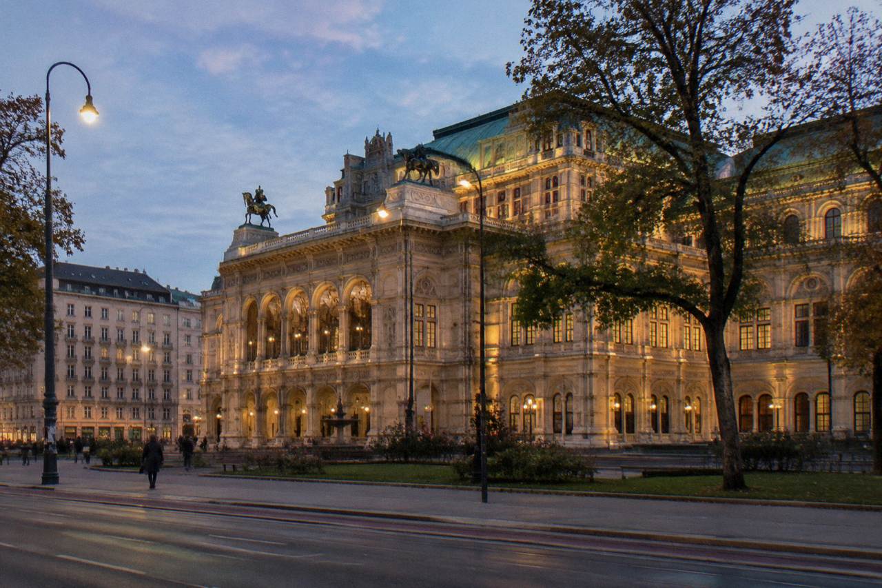 The State Opera building on the Ringstrasse seen from across the street at dusk with warm facade lighting