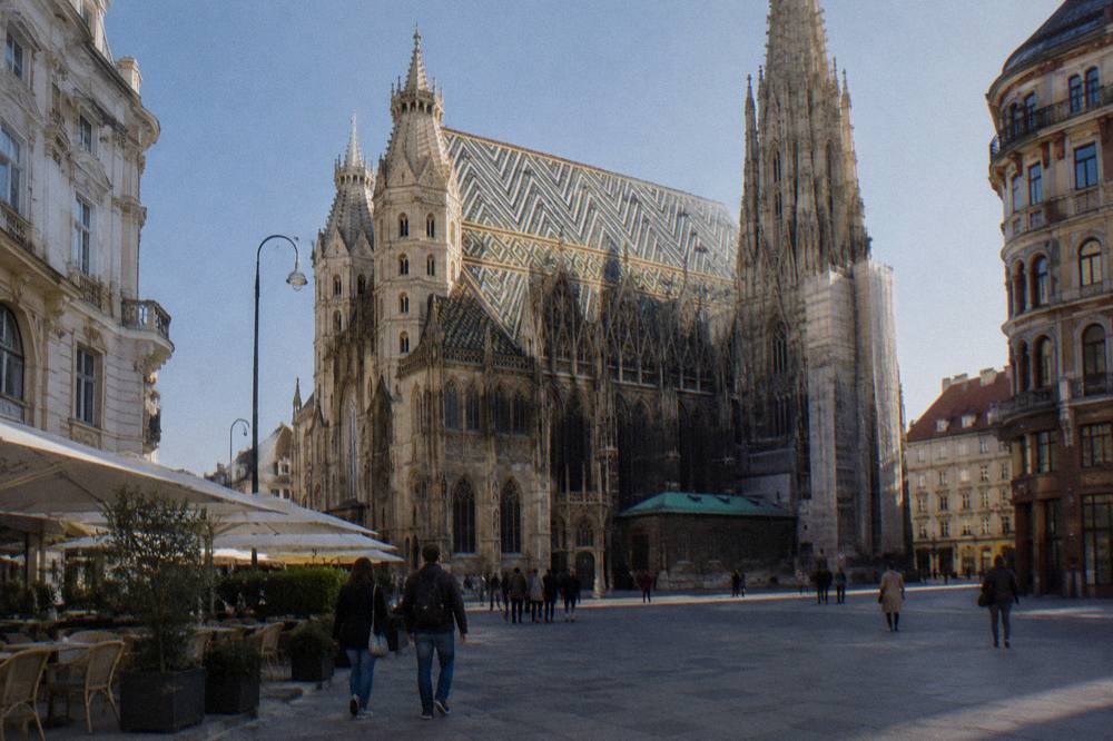 The cathedral's patterned tiled roof above the square, seen from the Stephansplatz paving on a clear afternoon