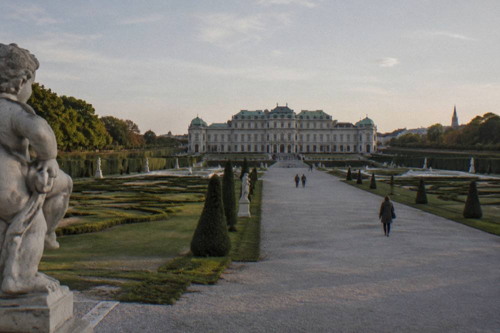 Sculpted hedges and a wide gravel walkway between the Upper and Lower Belvedere palaces seen from the middle terrace