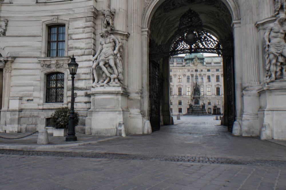 The archway of the Michaelertor opening onto the Hofburg's inner courtyard, seen from the square with nobody in the frame