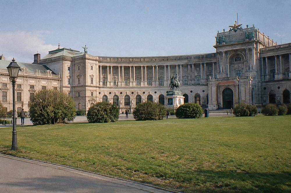 The curved colonnaded Neue Burg wing across the empty lawn of Heldenplatz in clear light