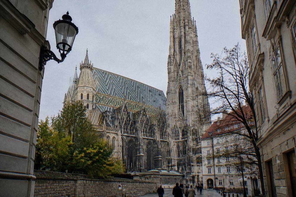 The cathedral's tiled roof and stone south tower under a cold pale sky, seen from a side street in the old town