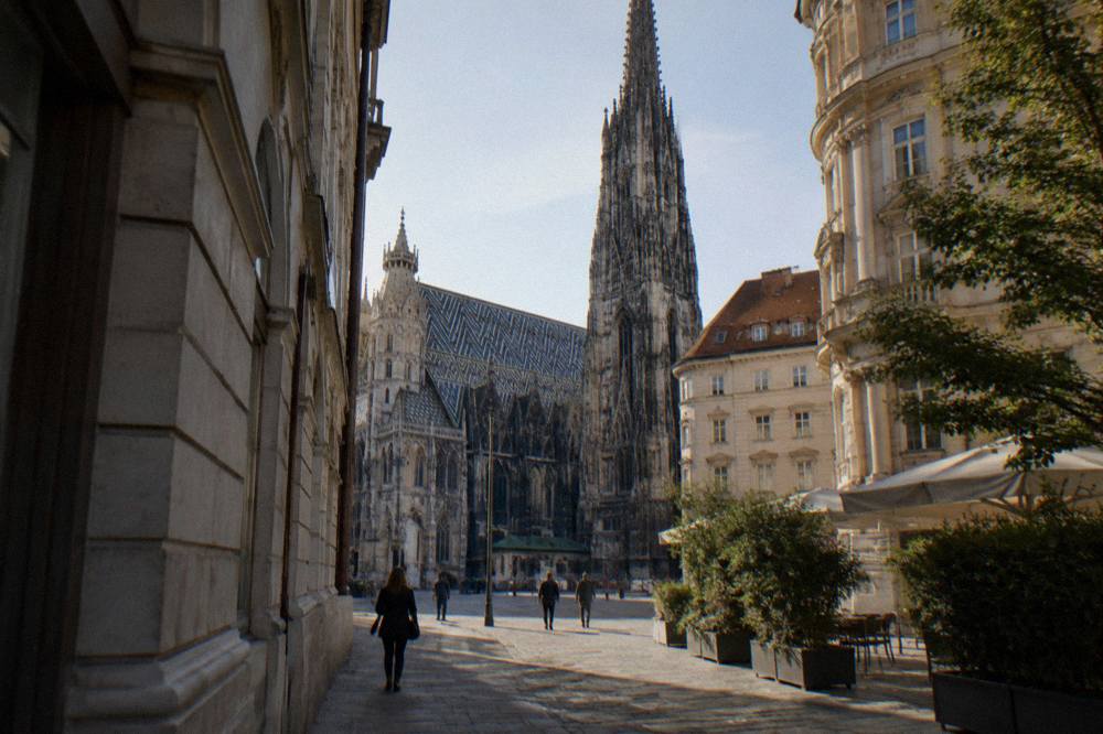 The Gothic south tower seen from a narrow street leading into Stephansplatz with morning shadows on the cobbles