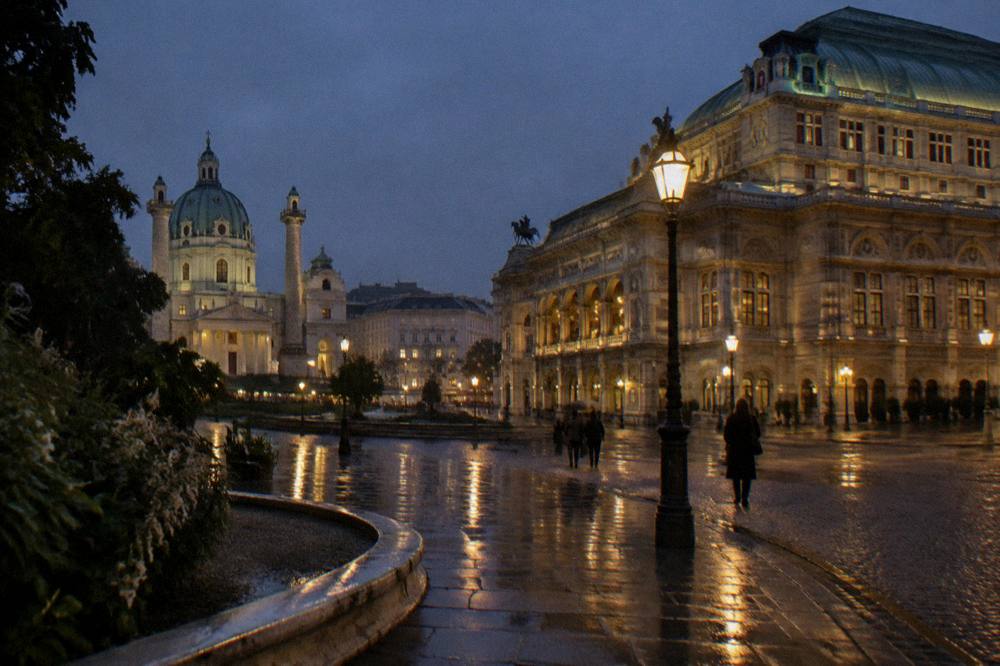 Wet cobbles reflecting the glow of Opernring street lamps at night near the State Opera, with no signage in view